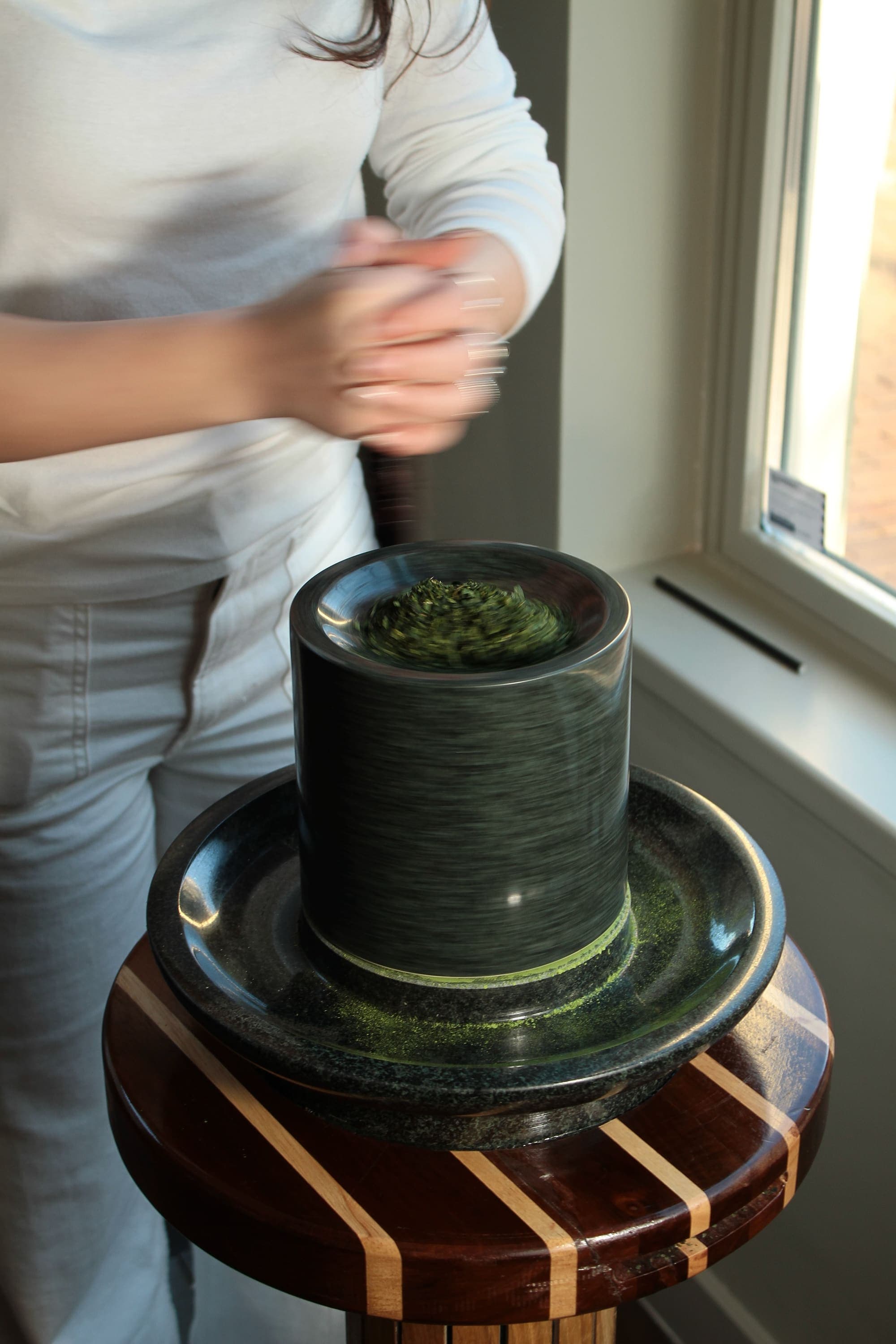 Matcha die wordt gemalen op een traditionele granieten steen bij KYŌ-KLUB